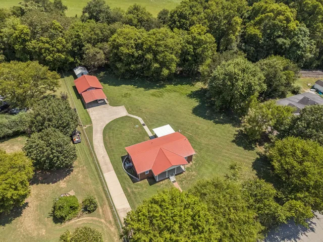 an aerial view of a house with swimming pool and outdoor seating