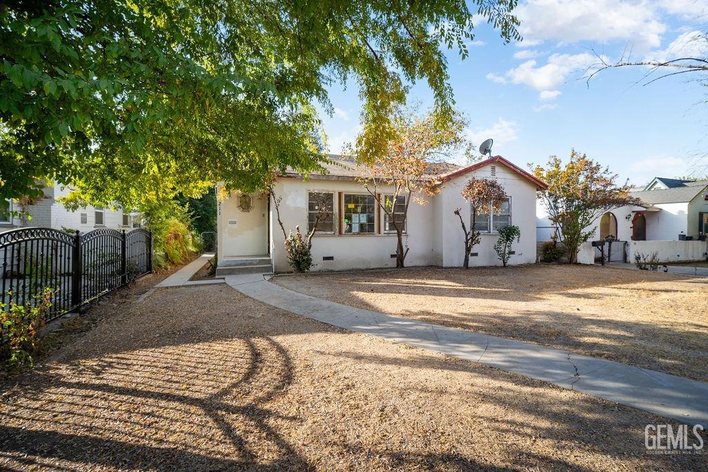 a view of a house with a yard and large trees