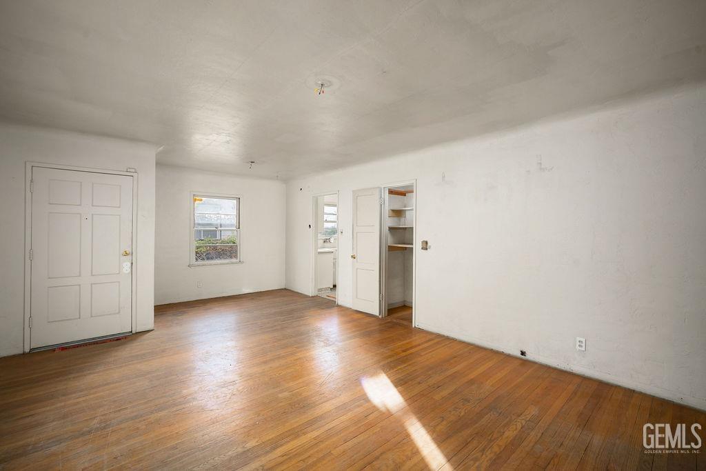 Undisclosed Address Bakersfield, CA 93305 - Photo 4 of 19 an empty room with wooden floor & windows and closet