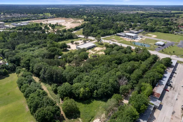 an aerial view of residential houses with outdoor space and trees