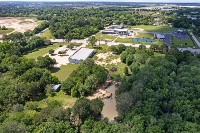 an aerial view of residential houses with outdoor space and river