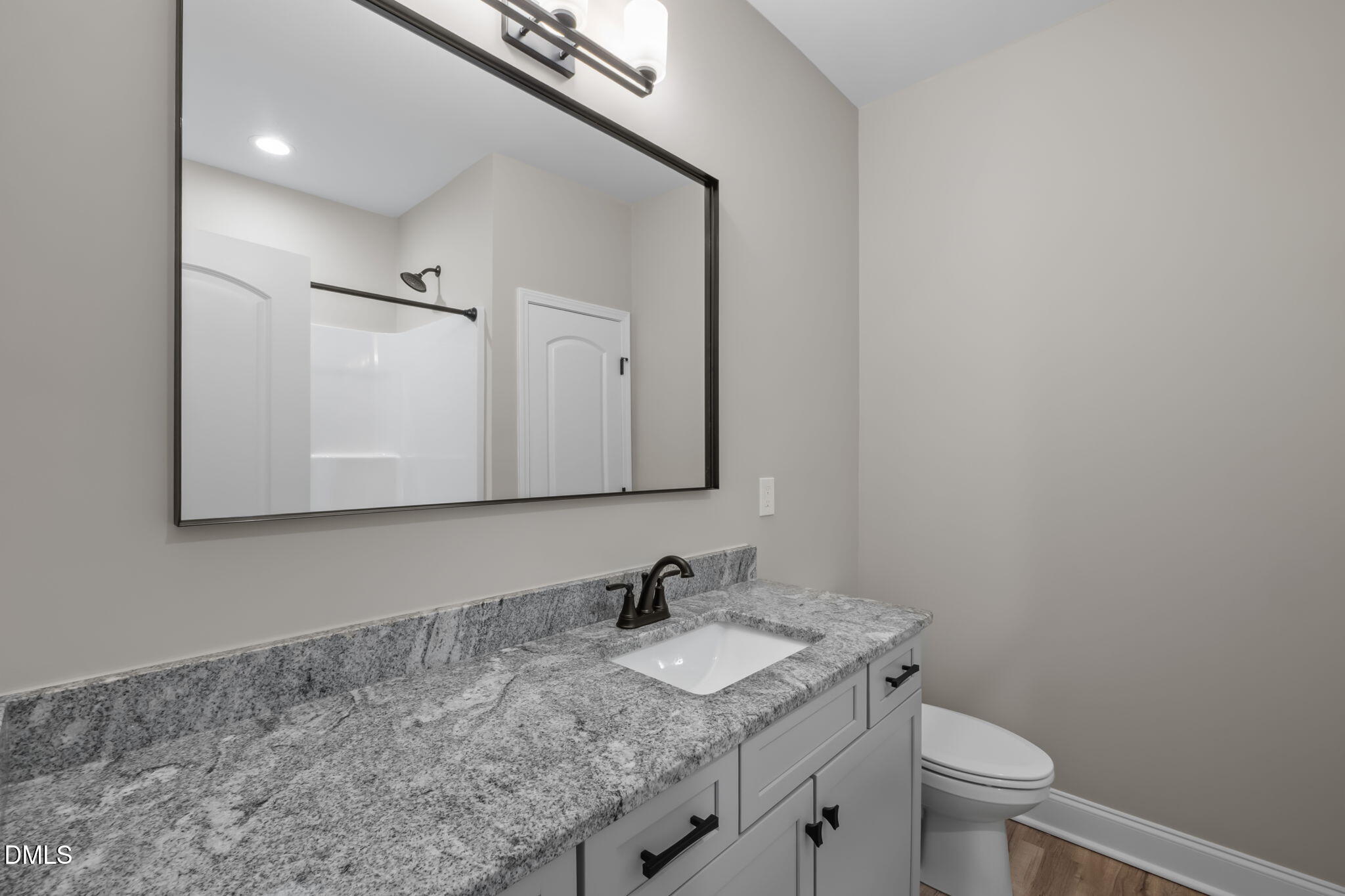 8514 Charlie Stovall Road Roxboro, NC 27574 - Photo 26 of 48 a bathroom with a granite countertop sink a toilet and a mirror