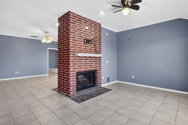 a view of an empty room and chandelier fan