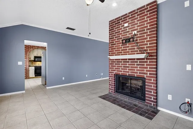 a view of an empty room with a fireplace and a window