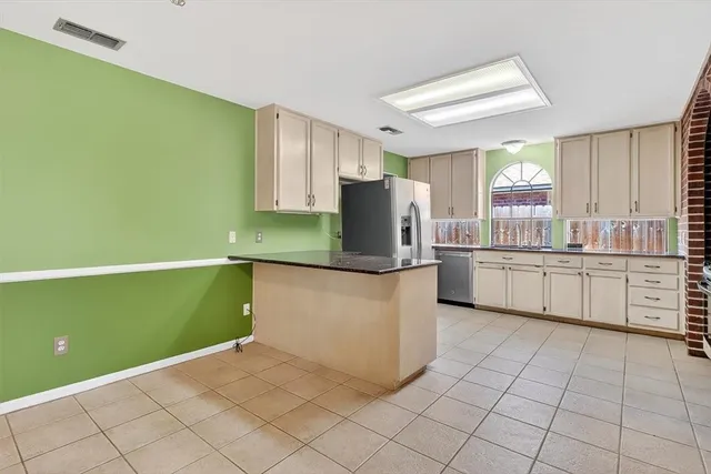 a kitchen with a refrigerator and white cabinets