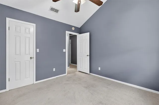 an empty room with chandelier fan