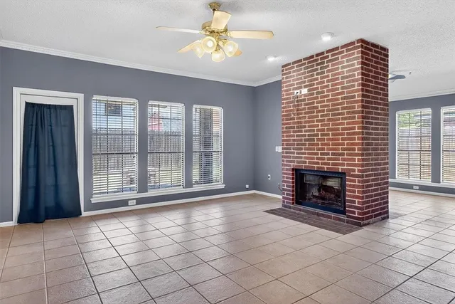 a view of an empty room with a fireplace and a window