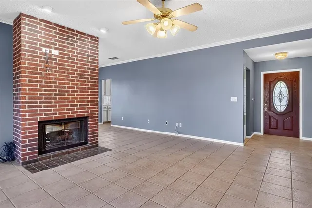 a view of an empty room with window and fireplace