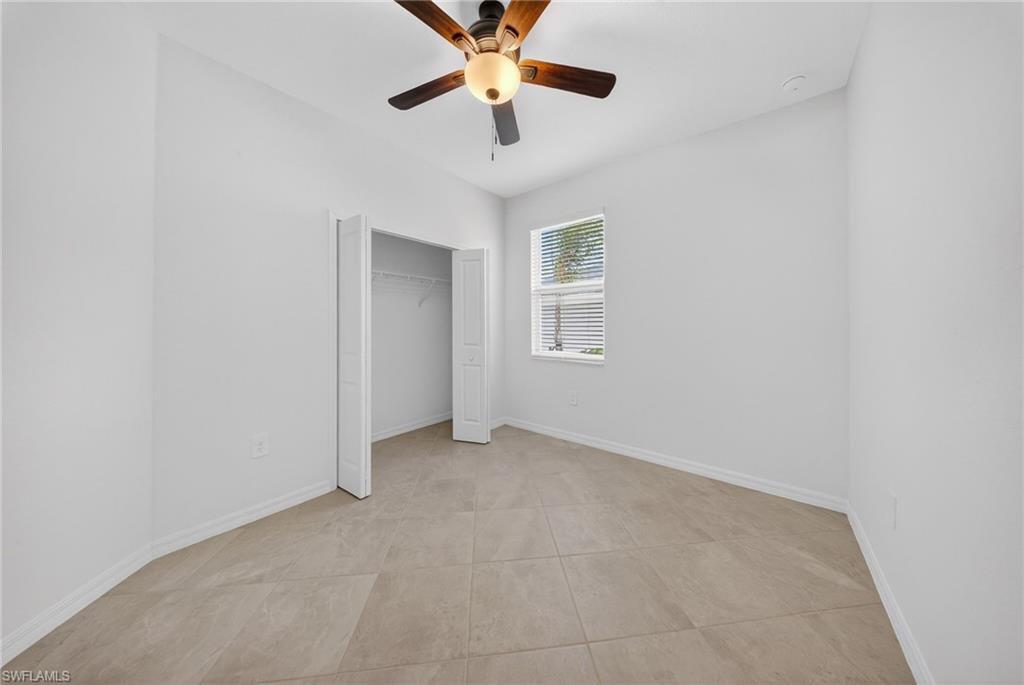 2224 Dragonfruit Way Naples, FL 34120 - Photo 15 of 33 Unfurnished bedroom featuring ceiling fan and a closet