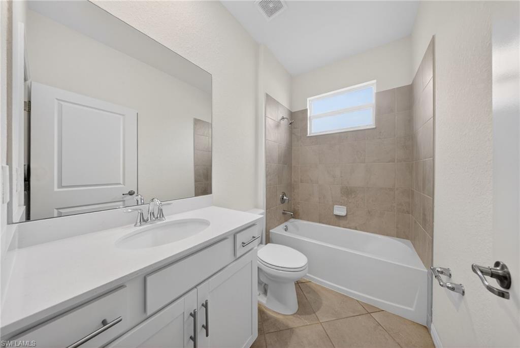 2224 Dragonfruit Way Naples, FL 34120 - Photo 17 of 33 Bathroom featuring vanity, bathtub / shower combination, and light tile patterned flooring