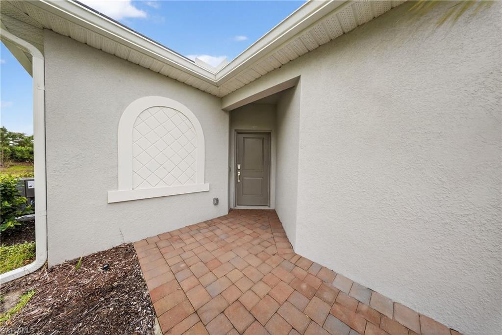 2224 Dragonfruit Way Naples, FL 34120 - Photo 2 of 33 Doorway to property with stucco siding