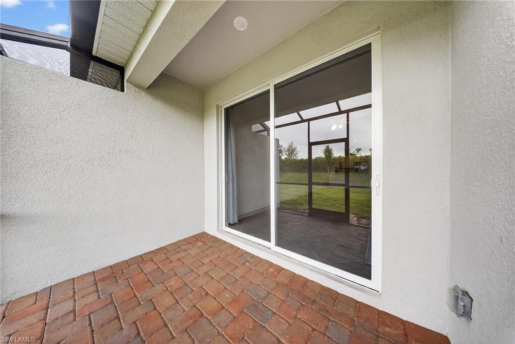 2224 Dragonfruit Way Naples, FL 34120 - Photo 24 of 33 Property entrance featuring stucco siding and a patio area