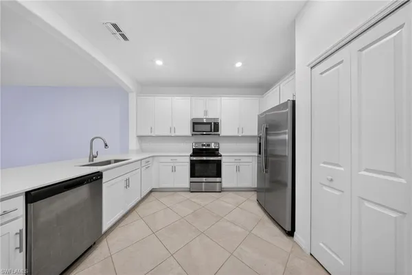 a kitchen with granite countertop a refrigerator and a sink