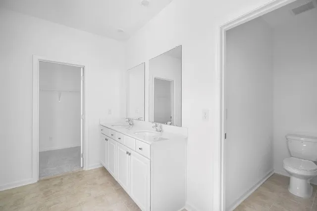 a spacious bathroom with a sink a toilet and a mirror