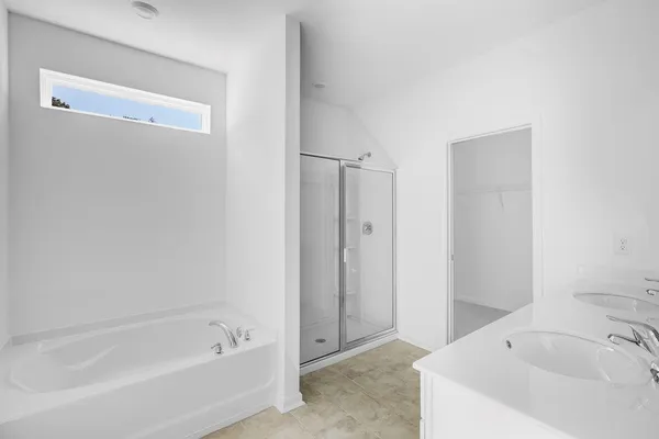 a white bath tub sitting next to a white sink and vanity