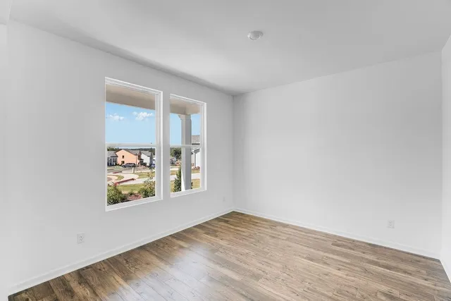 wooden floor in an empty room with a window