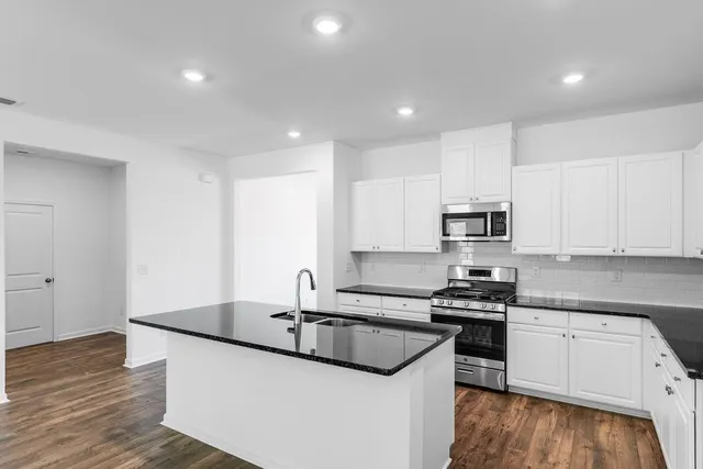 a kitchen with stainless steel appliances a sink stove and cabinets