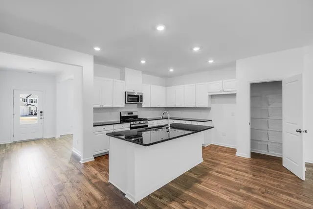 a kitchen with stainless steel appliances a stove a sink and a refrigerator