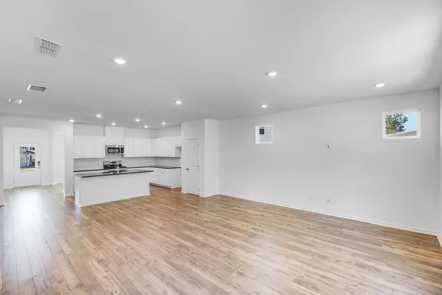 a open kitchen with kitchen island a sink stainless steel appliances and white cabinets