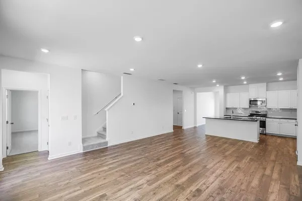 a view of kitchen with kitchen island wooden floor center island and stainless steel appliances