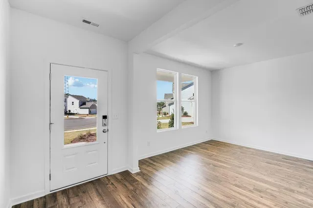 an empty room with wooden floor and window