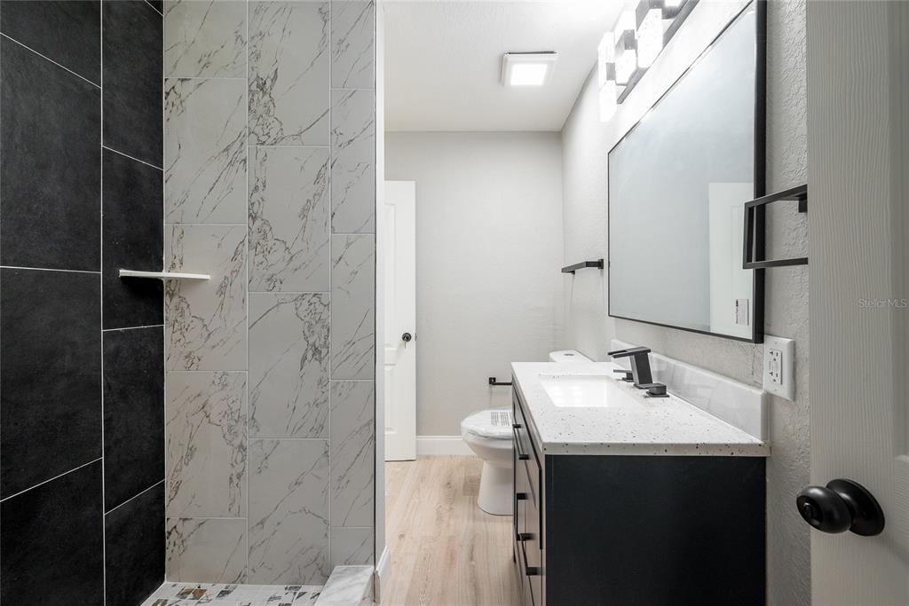 922 Delaware Avenue St. Cloud, FL 34769 - Photo 13 of 31 a bathroom with a sink and mirror