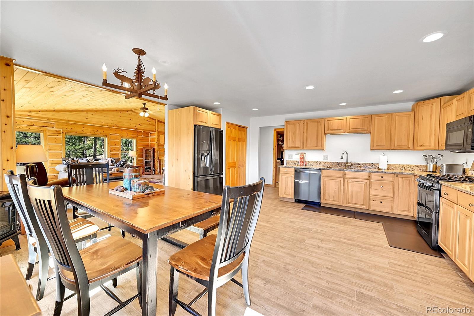 278 Clark Road Bailey, CO 80421 - Photo 16 of 44 a open dining room with stainless steel appliances kitchen island granite countertop a sink a stove a dining table and chairs