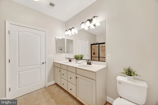 a spacious bathroom with a granite countertop sink mirror and toilet