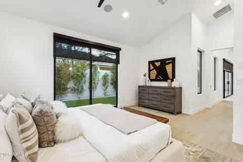 a bedroom with a bed and a potted plant on the dresser