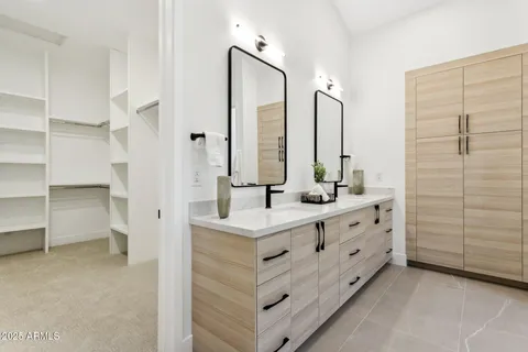 a bedroom with a bed and a flat tv screen next to a window
