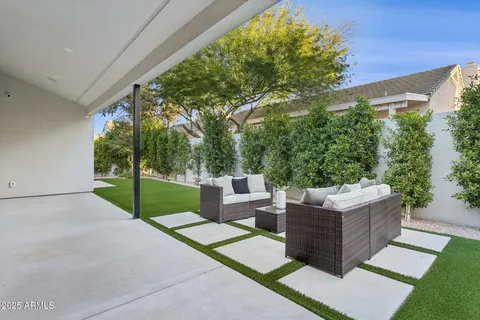 a view of a backyard with couches plants and large tree
