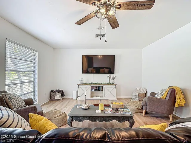 a living room with furniture kitchen view and a flat screen tv