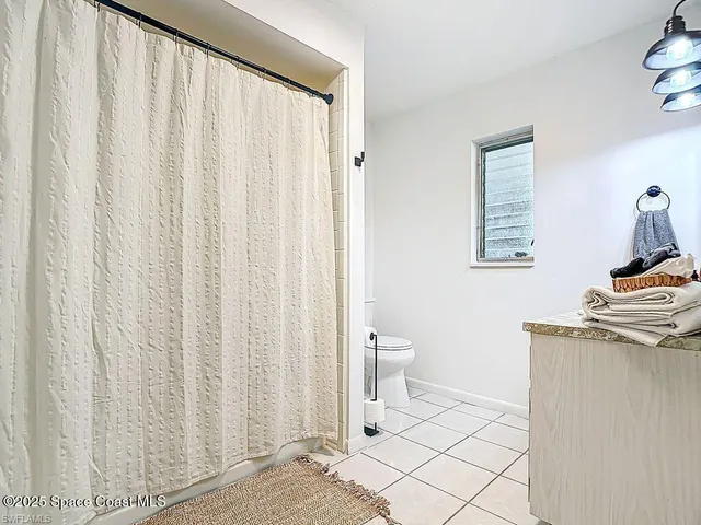 a bathroom with a toilet a sink and curtain