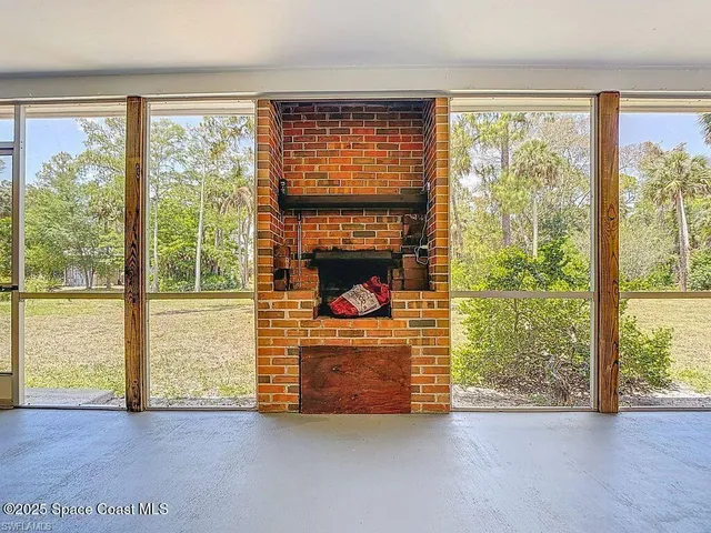 a view of an empty room with wooden floor and a floor to ceiling window