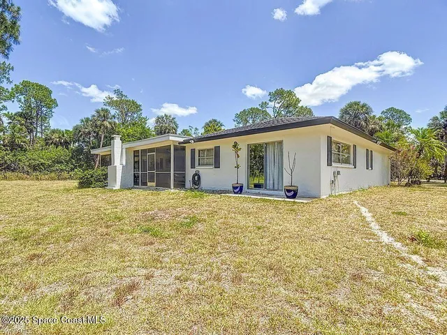 a view of a house with backyard and garden