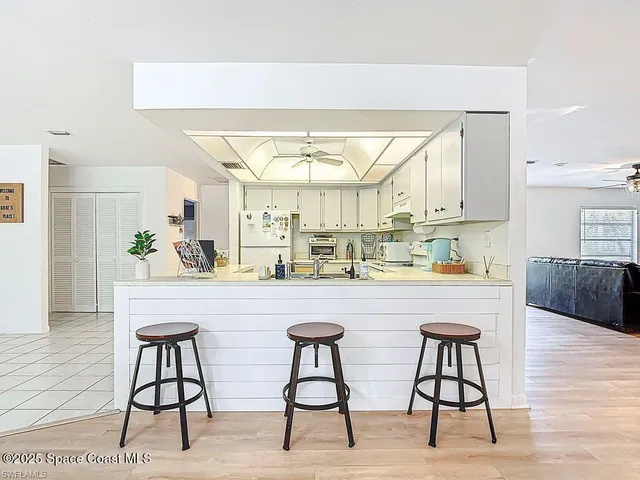 a kitchen with stainless steel appliances a kitchen island a stove a table and chairs in it