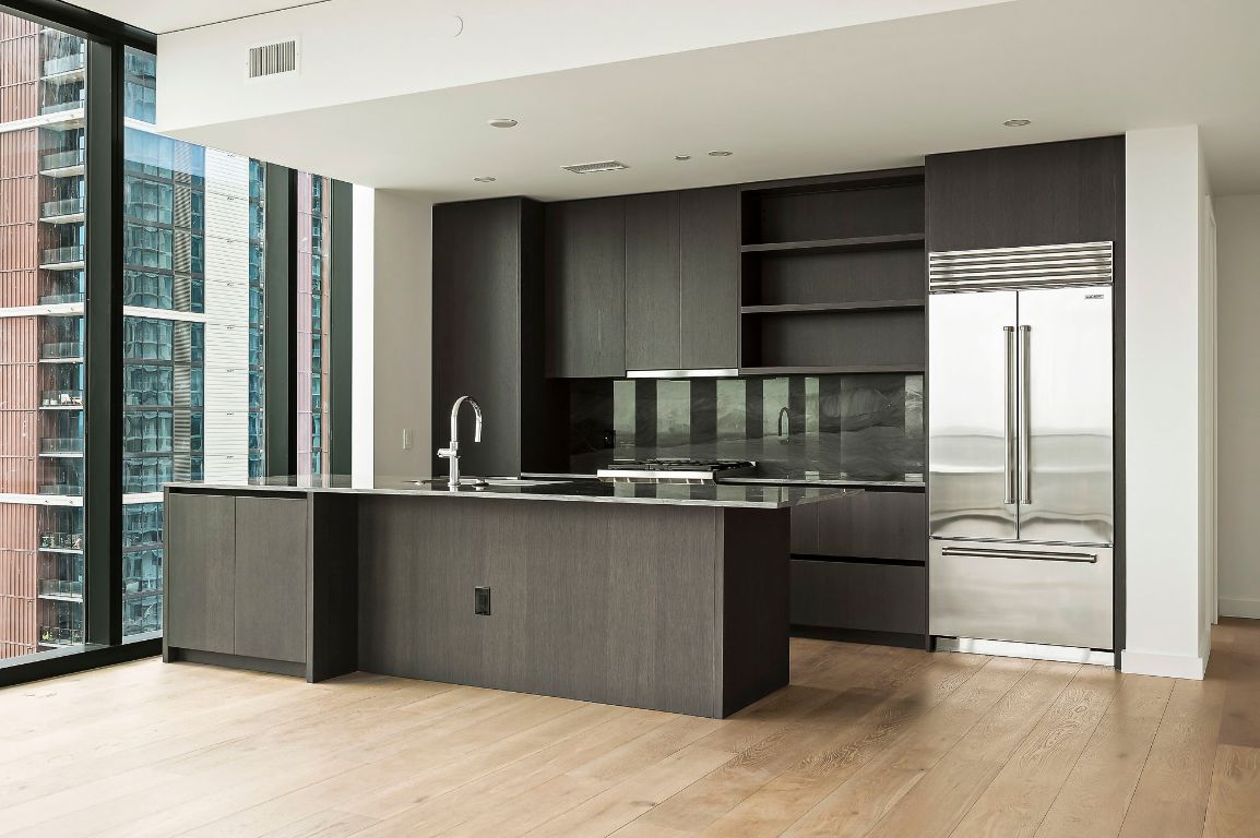 a kitchen with stainless steel appliances granite countertop a refrigerator and a sink