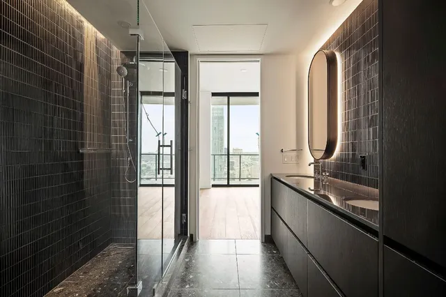 a bathroom with a granite countertop sink a toilet and shower