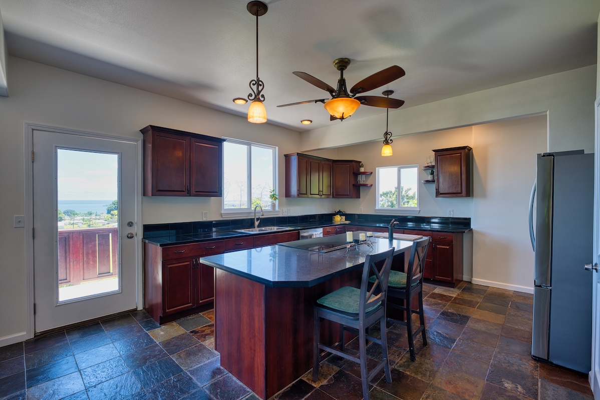 149 Halai Street Hilo, HI 96720 - Photo 11 of 26 a kitchen with stainless steel appliances granite countertop a sink a stove a dining table and chairs with wooden floor