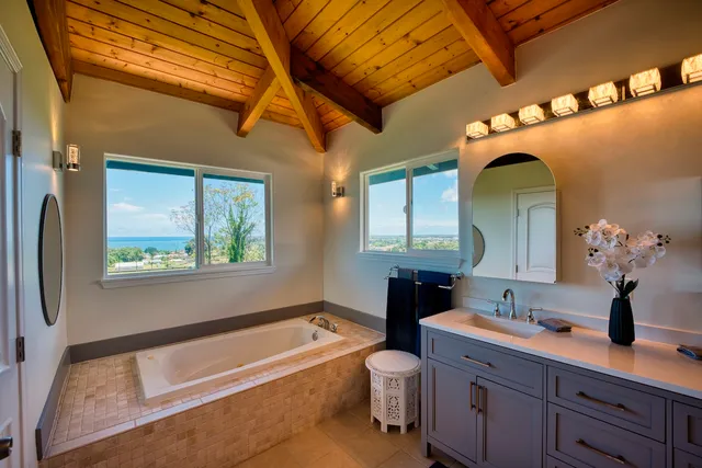 a bathroom with a tub sink and mirror
