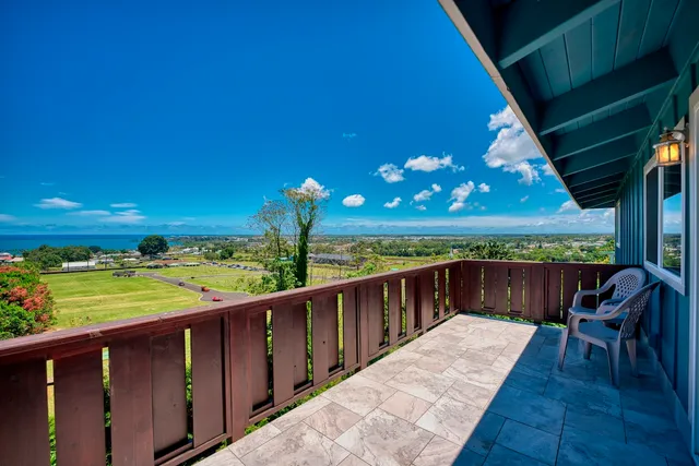 a balcony with wooden floor table and chairs