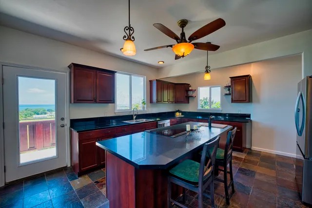 a kitchen with stainless steel appliances a table chairs refrigerator and microwave