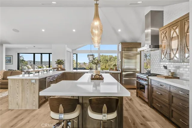 a view of a dining room with furniture a kitchen and chandelier