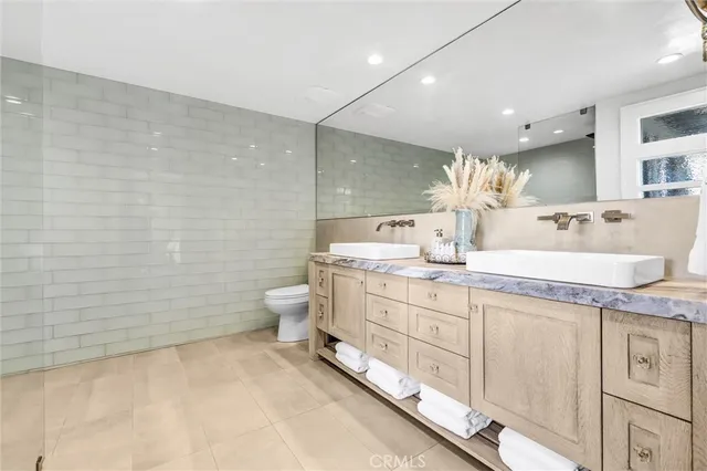 a bathroom with a granite countertop sink a toilet and a shower