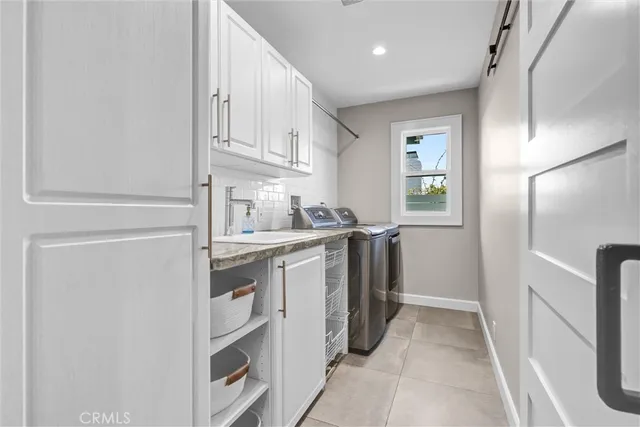 a kitchen with white cabinets and refrigerator