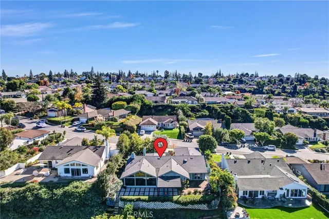 an aerial view of residential houses with outdoor space and trees