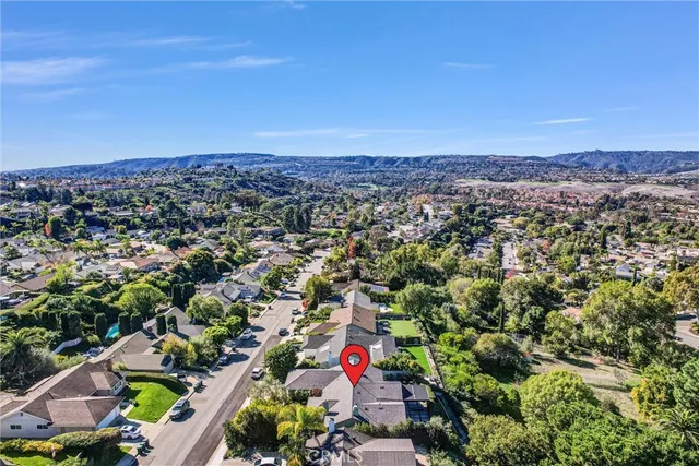 an aerial view of a house with a yard and large trees