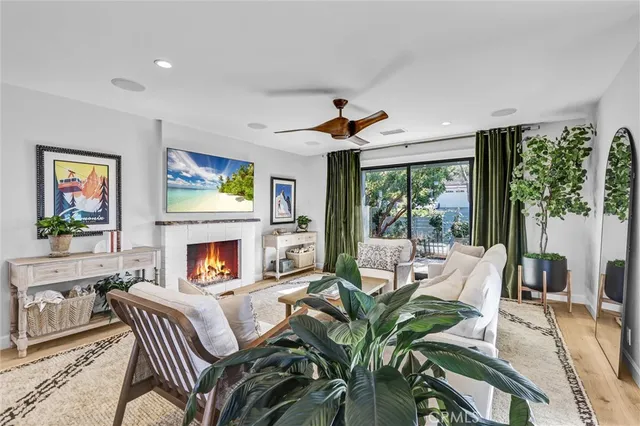a living room with furniture fireplace and large windows
