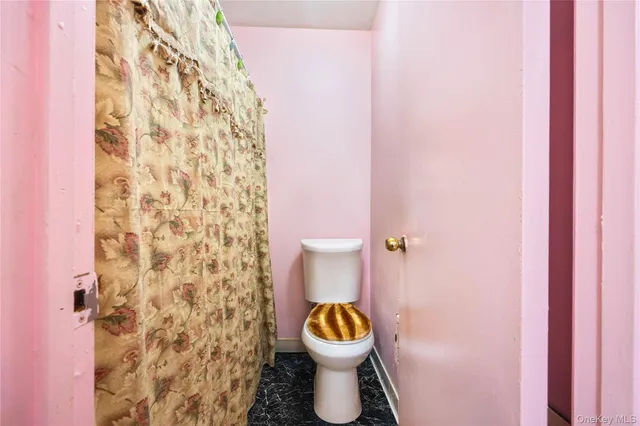 a bathroom with a toilet and a shower curtain
