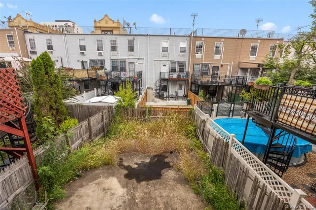 a view of a brick house with many windows next to a yard